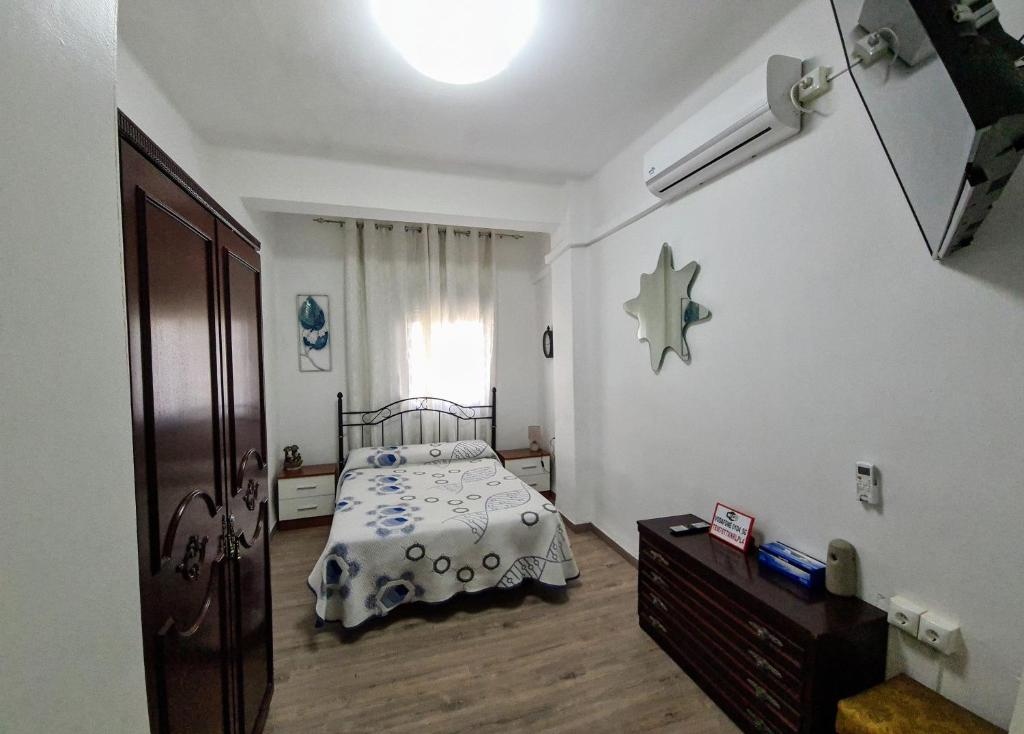 a bedroom with a bed and a dresser and a window at Habitación San Cayetano in Valencia