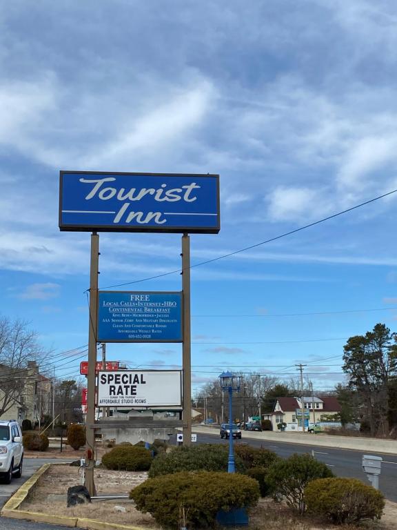 una señal para una posada del suroeste al lado de una carretera en Tourist Inn, en Absecon