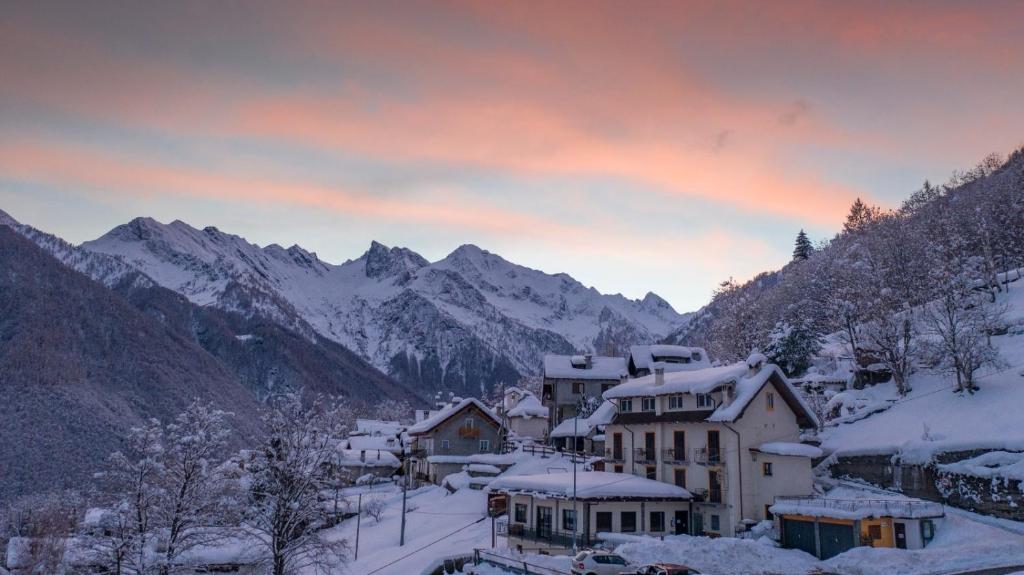 a village covered in snow with mountains in the background at Da Cecilia in Bognanco