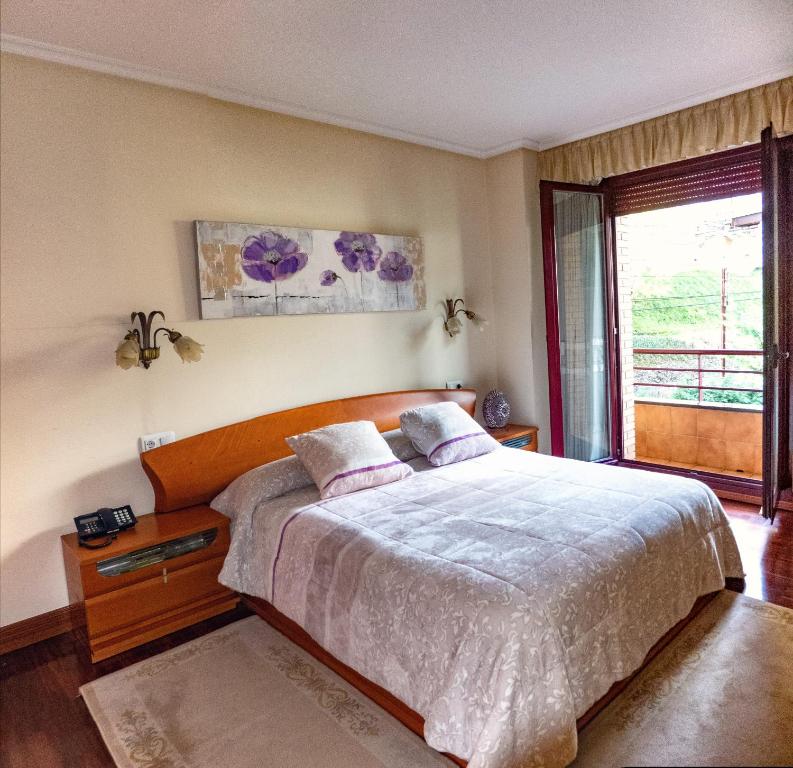 Un dormitorio con una cama grande y una ventana en EL ENLACE, en Elgóibar