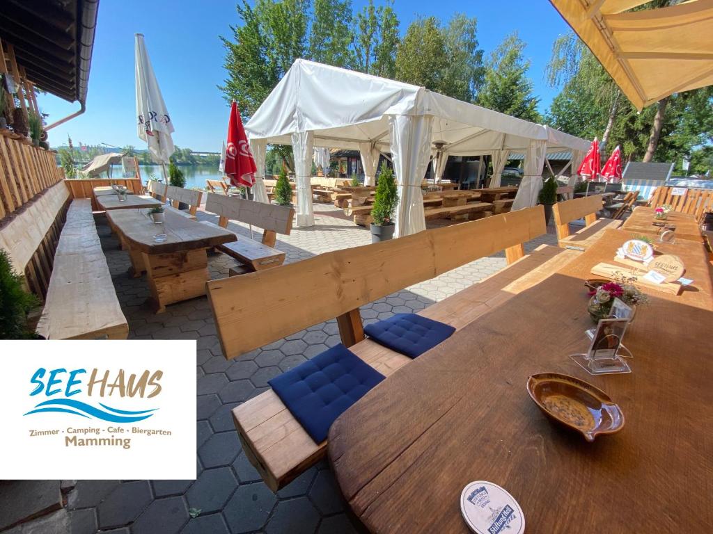 a patio with a table and chairs and a tent at Seehaus Mamming - Hotel - Schlaffässer - Biergarten - Camping in Mamming