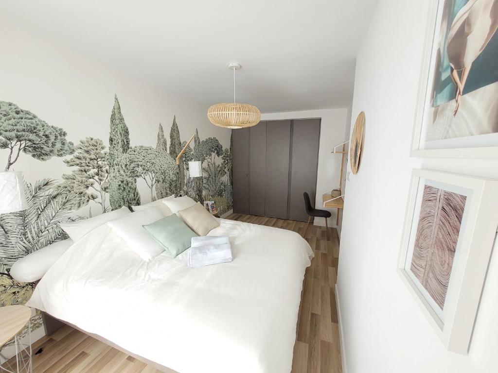 ein Schlafzimmer mit einem weißen Bett und Pflanzen an der Wand in der Unterkunft Sunny and calm 2 bed apartment place du Pin in Nizza