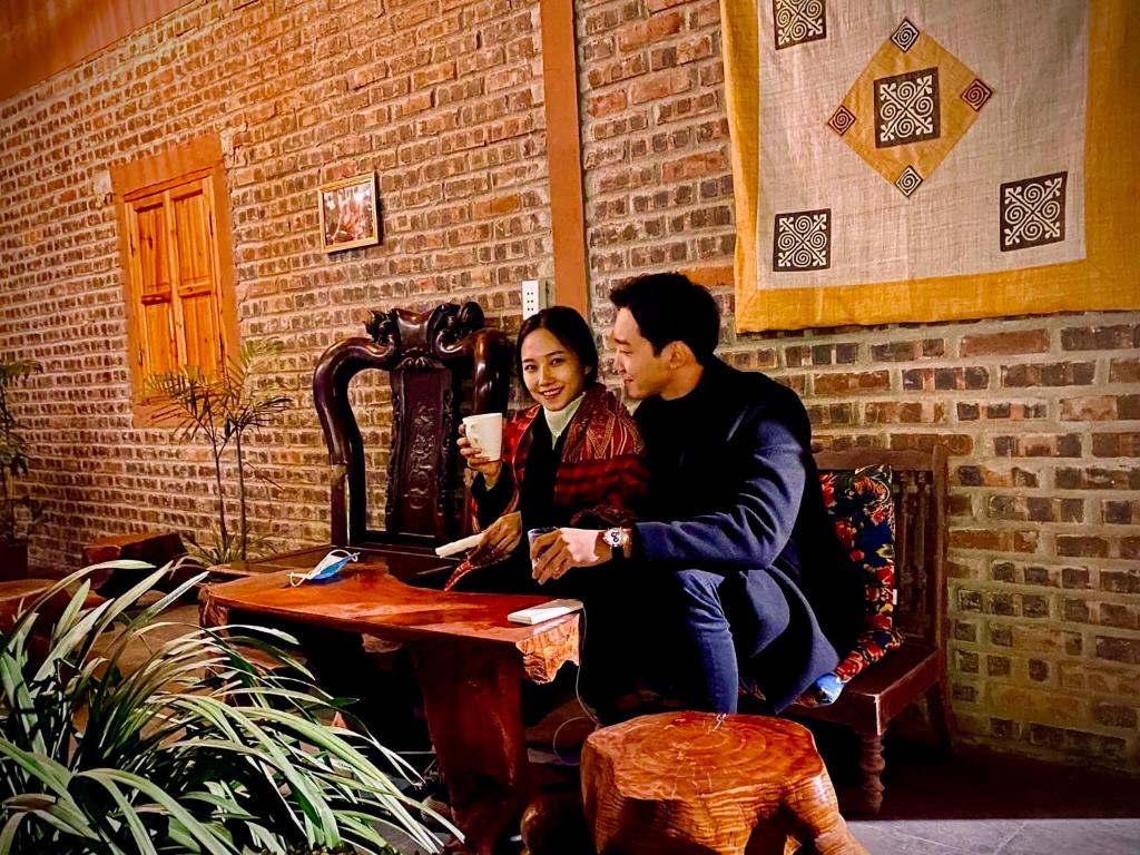 a man and a woman sitting at a table at Little Yen's Homestay in Mèo Vạc