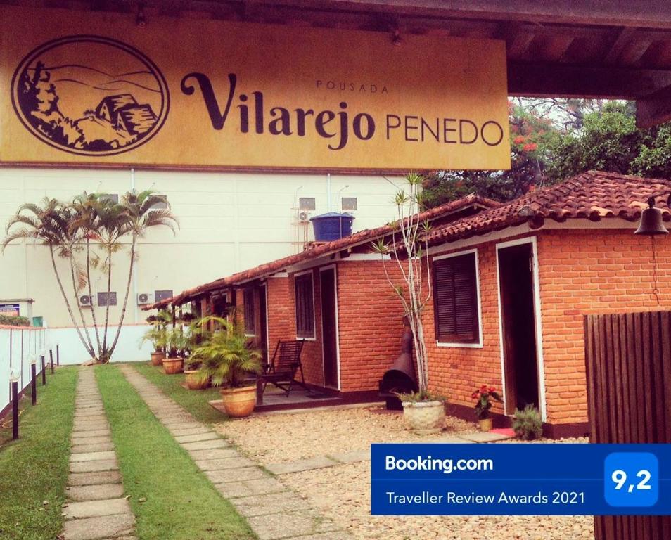 a building with a sign that reads virago penido at Vilarejo Penedo Chalés in Penedo