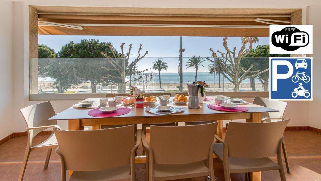 a dining room with a table with a view of the ocean at Apart-rent Apartament Av Rhode 2006 in Roses