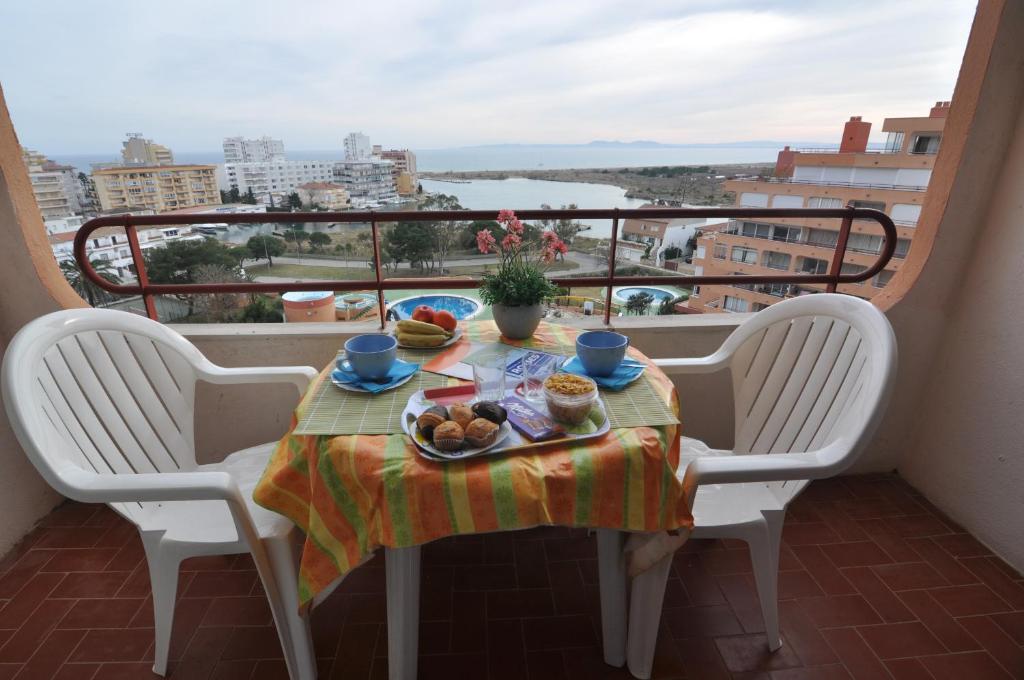 a table with a plate of food on a balcony at RNET - IR 7-29 Studios Roses Costa Brava in Roses