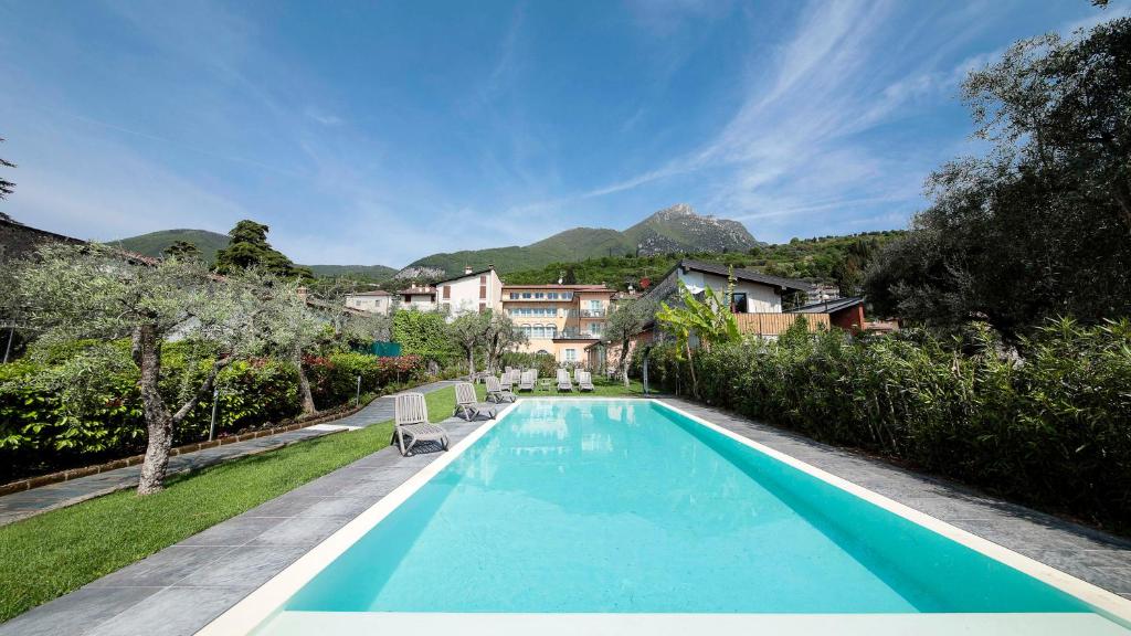 uma piscina com duas cadeiras ao lado de uma casa em Corte Benaco by Wonderful Italy em Toscolano Maderno