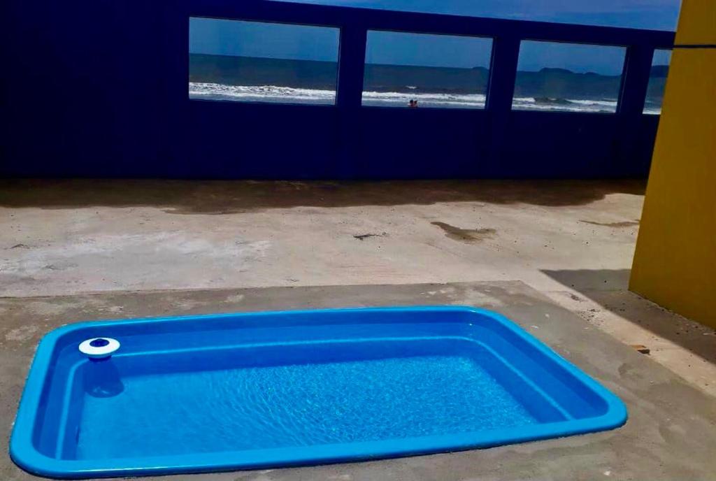 uma bandeja azul sentada no chão ao lado da praia em PÉ NA AREIA apartamento térreo em Itapoá