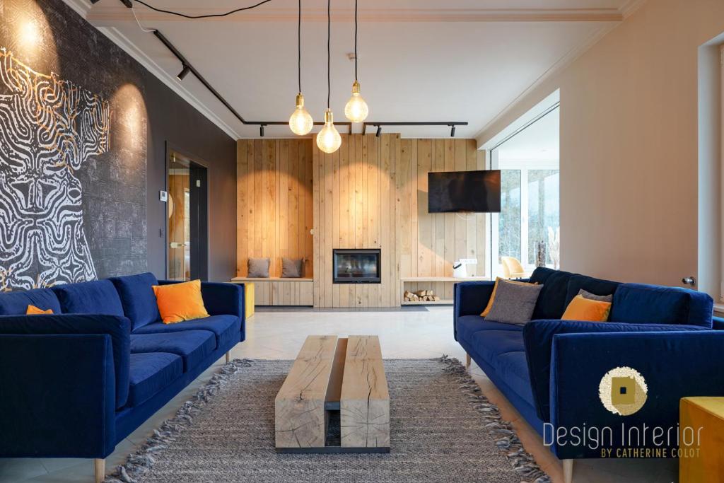 a living room with blue couches and a coffee table at Plein la vue in Barvaux