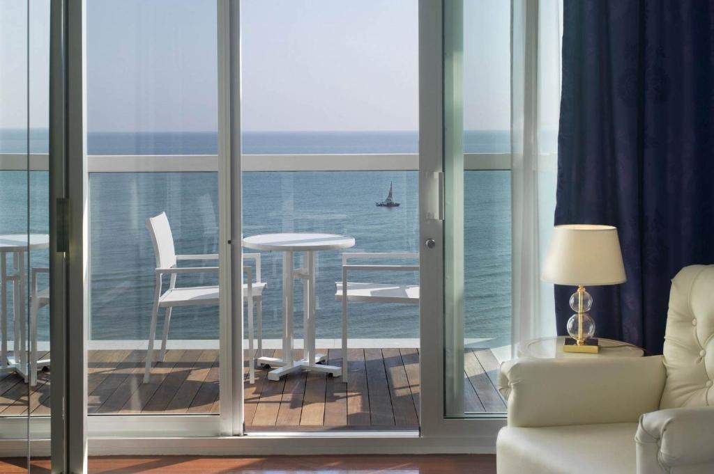 a living room with a view of the ocean at Hotel Tiffany's in Riccione