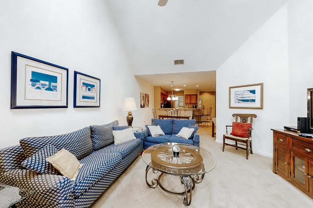 sala de estar con sofá azul y mesa en Colonnade Club 152 en Hilton Head Island