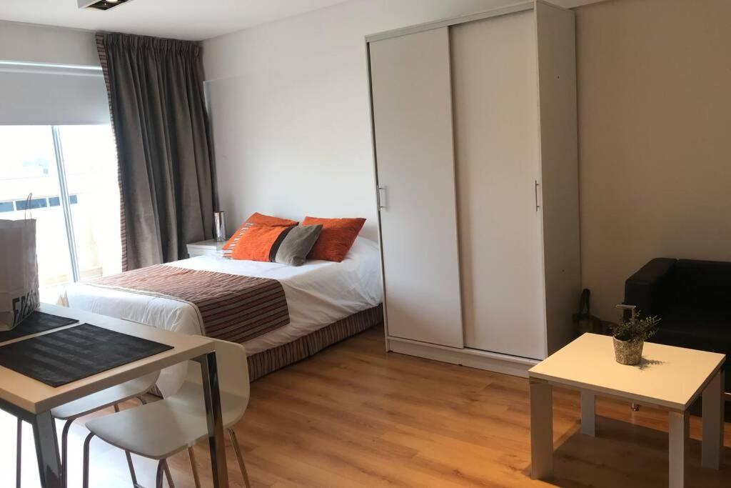 a bedroom with a bed and a desk with a laptop at Down Town Buenos Aires in Buenos Aires