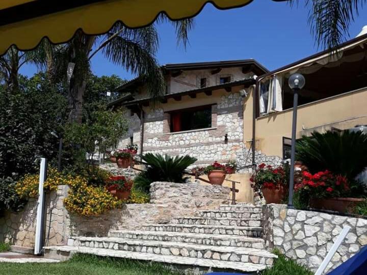 a house with a stone staircase in front of a building at Agriturismo La Valle Incantata Gerace - in Gerace