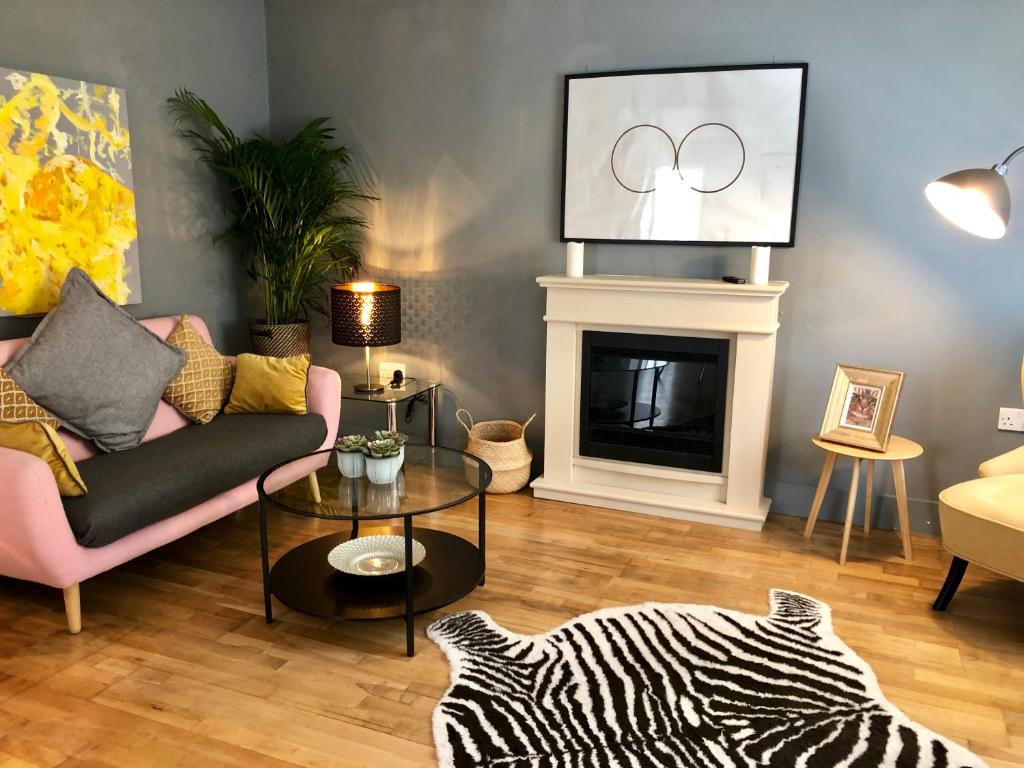 a living room with a couch and a fireplace at Charming Cottage & Garden - central Brighton! in Brighton & Hove