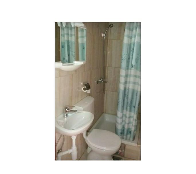 a bathroom with a sink and a toilet and a shower at Apartmani Kelava in Podgora
