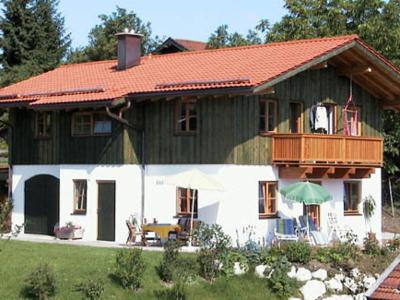 ein Haus mit einem orangenen Dach und einem Balkon in der Unterkunft Ferienwohnungen Wolfgang Geistanger in Siegsdorf