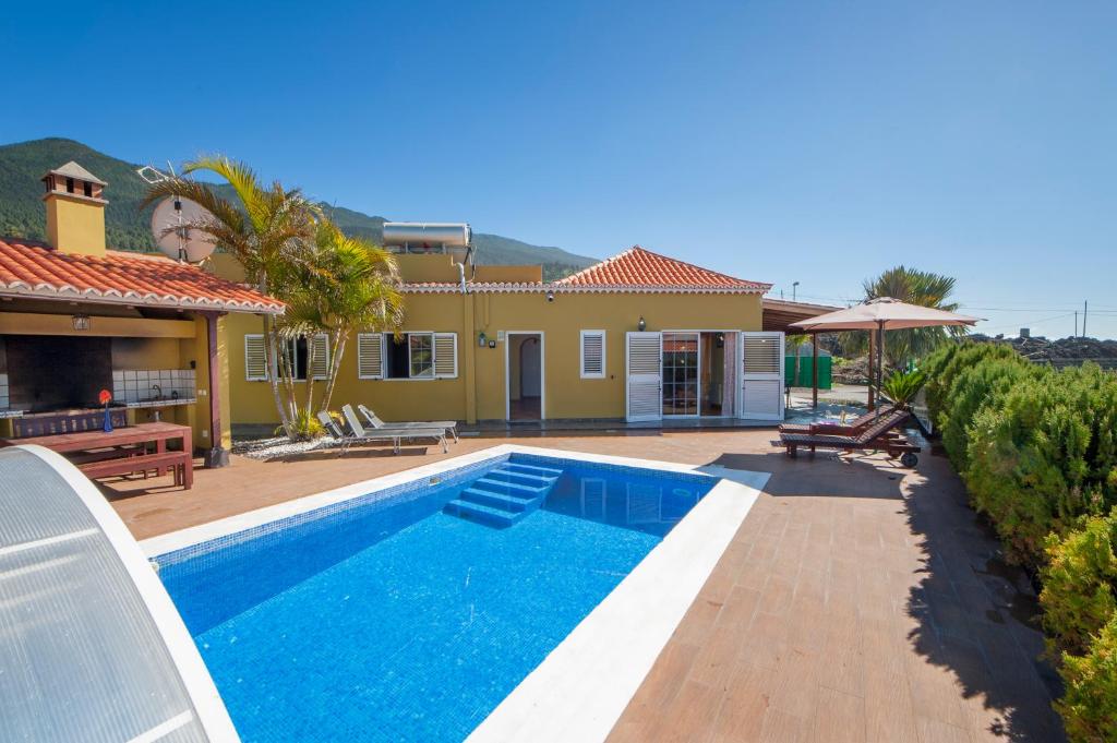 a swimming pool in front of a house at Villa Tamanca in El Paso