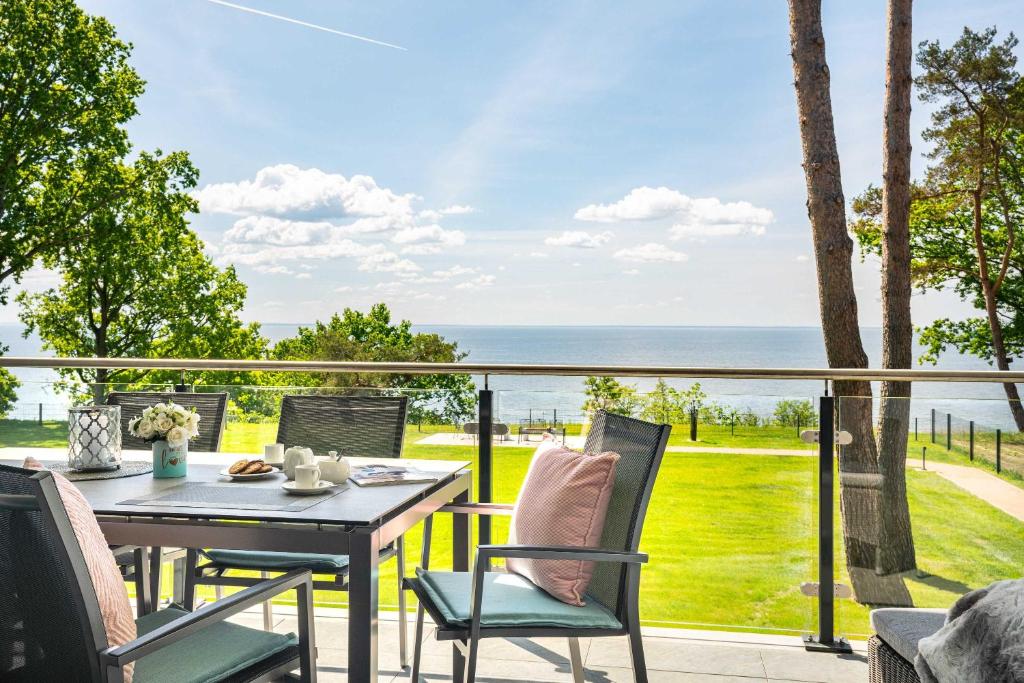 a table and chairs on a balcony with a view of the ocean at Appartement "Froschkönig" - Oase am Haff in Garz-Usedom