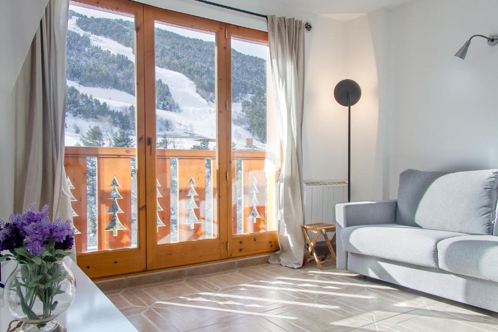 a living room with a couch and a large window at Apartamento Tarter Parc 1 habitación in Canillo