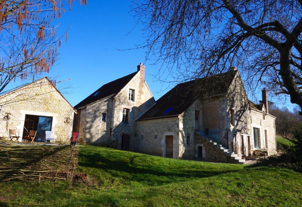 an old stone building on a grassy field at une oasis dans le perche in Rémalard en Perche