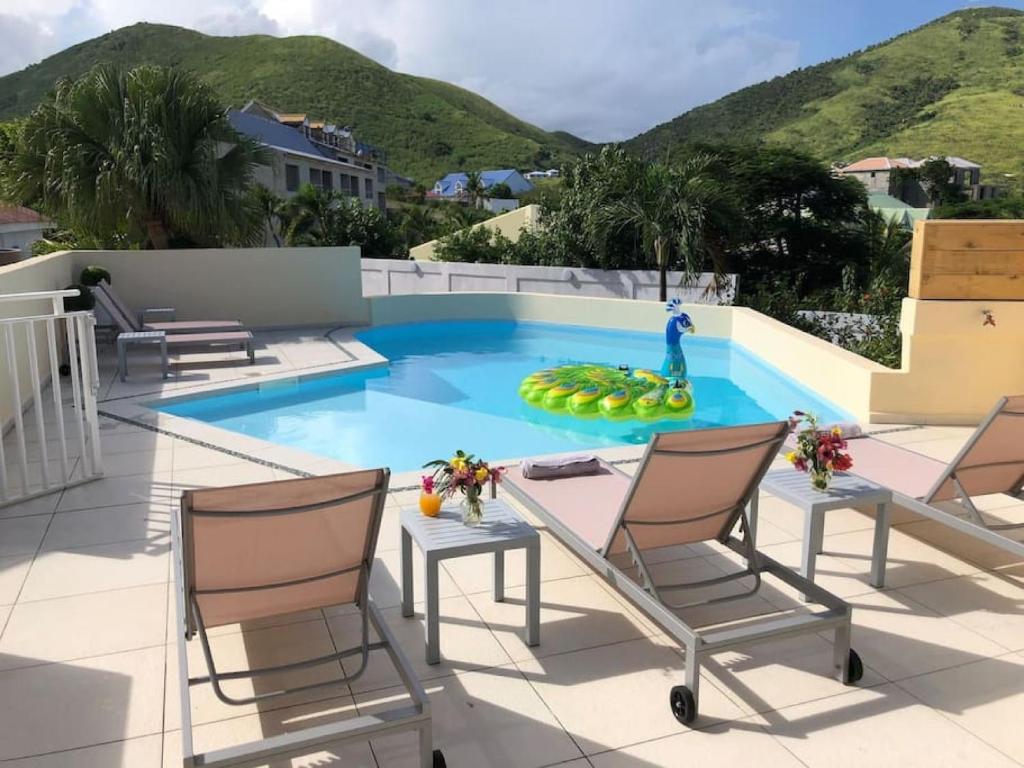 una piscina en el techo de una casa en Beautiful suite S18, pool, sea view, next to paradise Pinel Island, en Cul de Sac