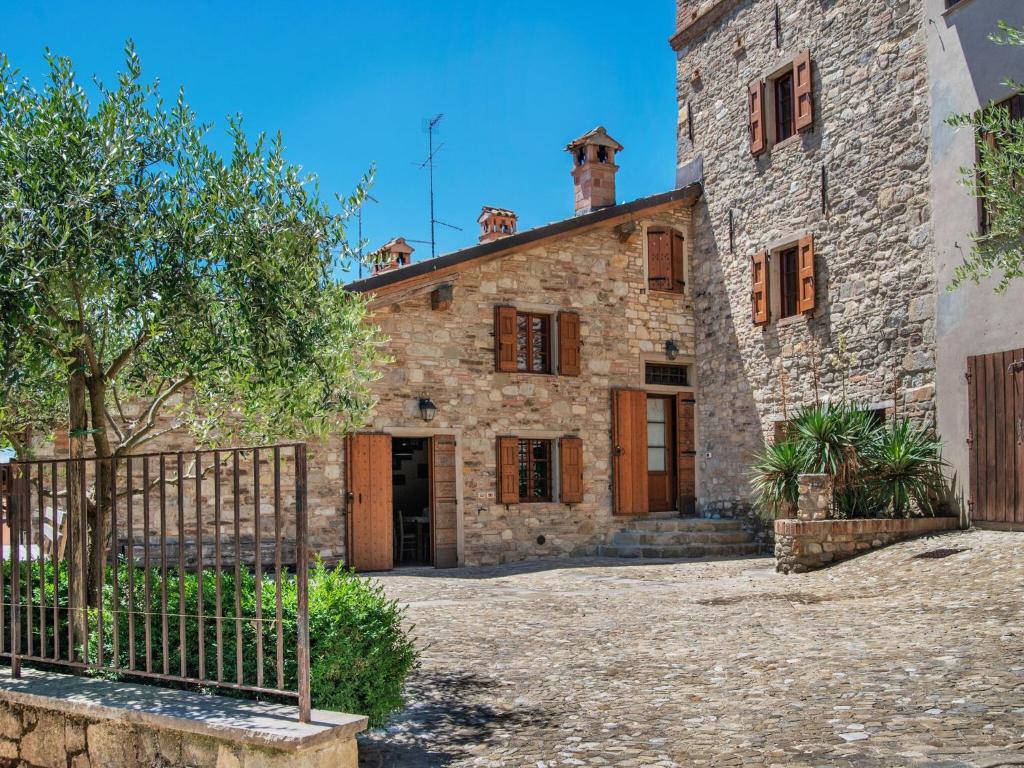 une ancienne maison en pierre avec un portail en face de celle-ci dans l'établissement Belvilla by OYO Aia, à Castellarano