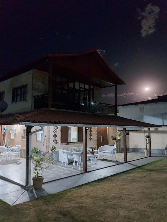 a house with a large deck at night at Casa em frente a praia de Jaconé in Saquarema