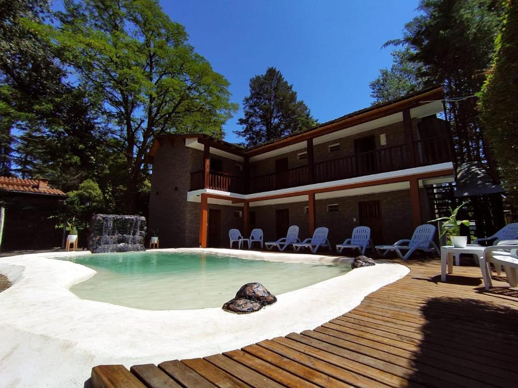 a house with a swimming pool with a wooden deck at Hotel Berlin in Villa General Belgrano