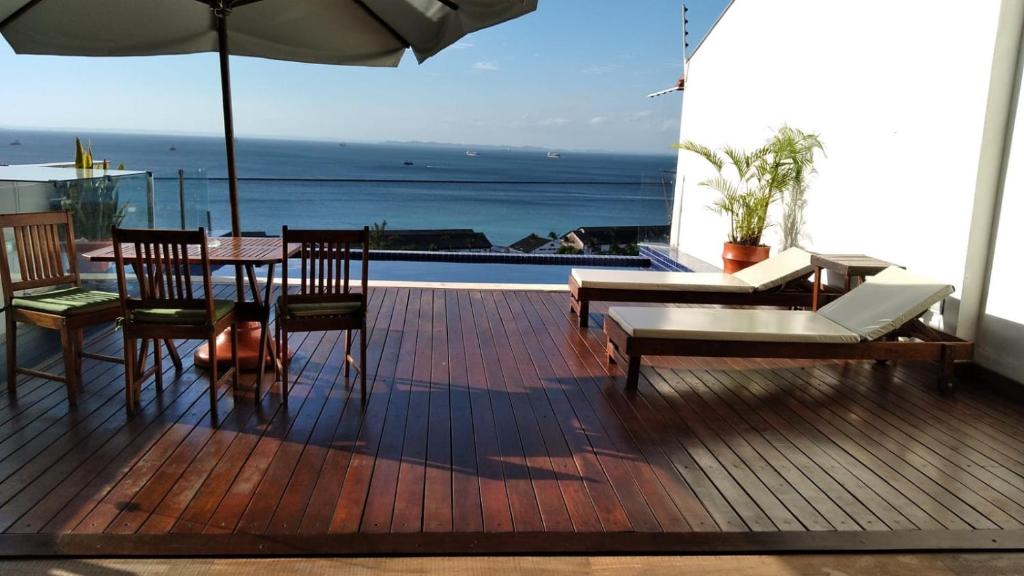 a deck with a table and chairs and an umbrella at Apartamento Centro Histórico in Salvador