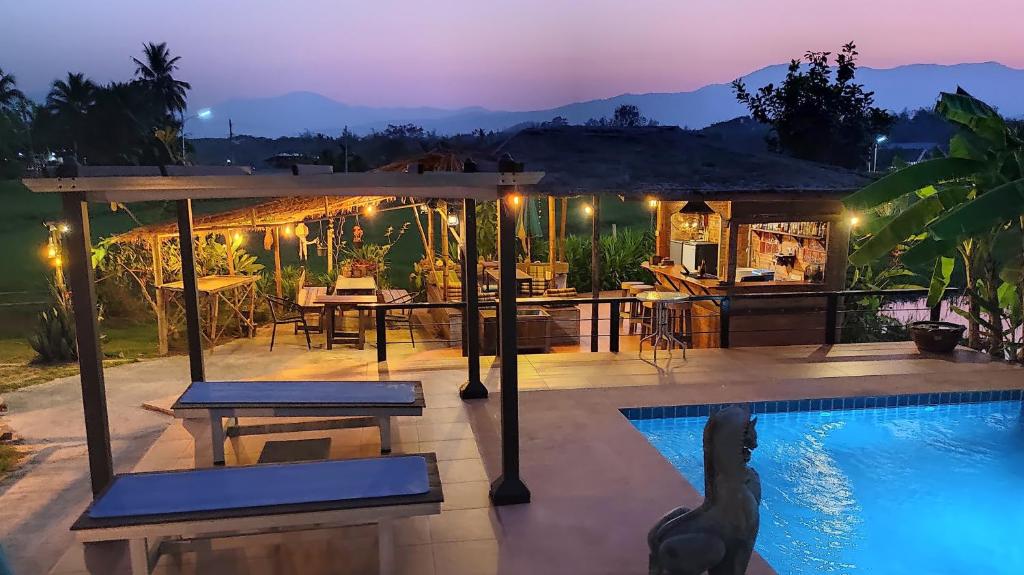 a villa with a swimming pool at night at Country Retreat in Mae Rim