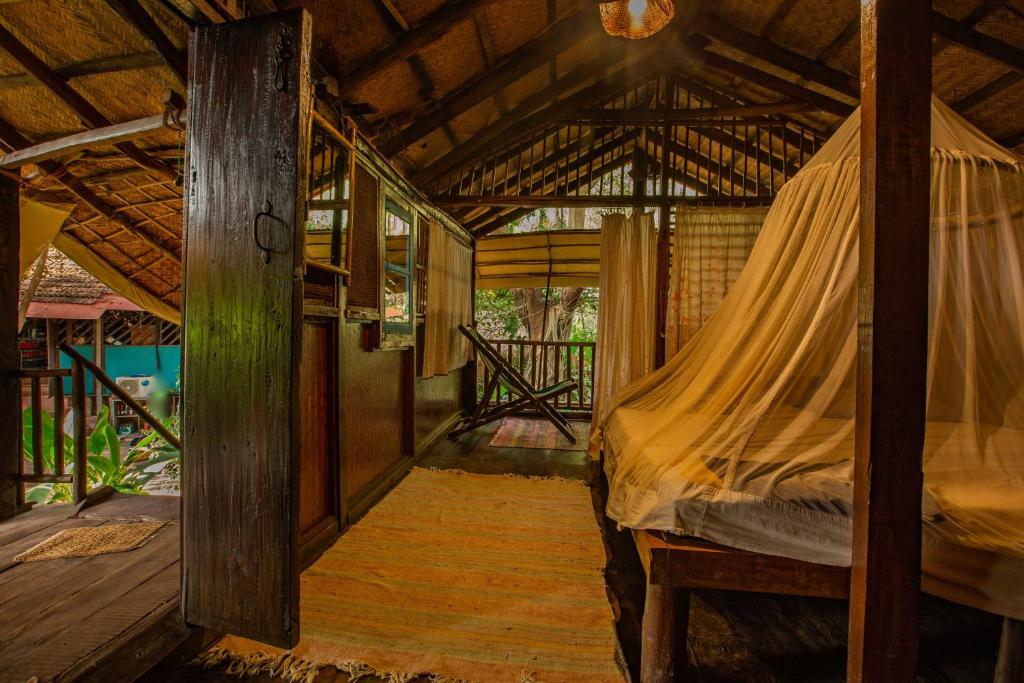 a bedroom with a bed with a mosquito net at Bhakti Kutir in Palolem
