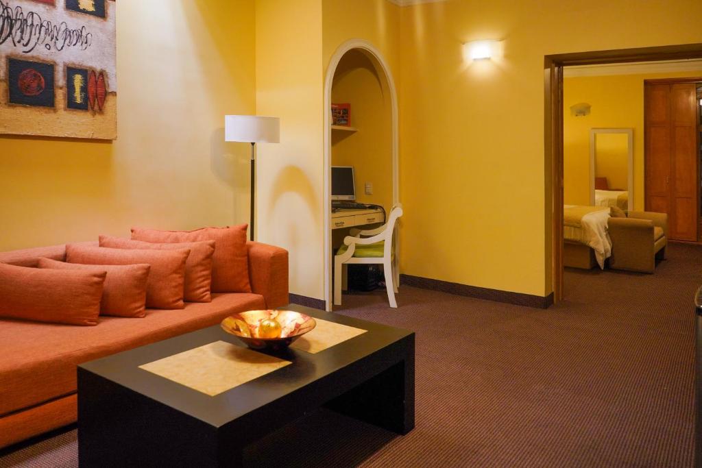 a living room with a couch and a table at Gran Hotel de Querétaro in Querétaro