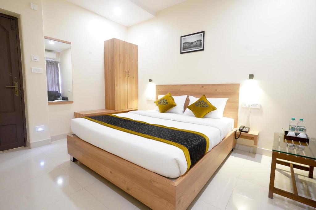 um quarto com uma cama grande e almofadas amarelas em Hotel Prime Inn em Warangal
