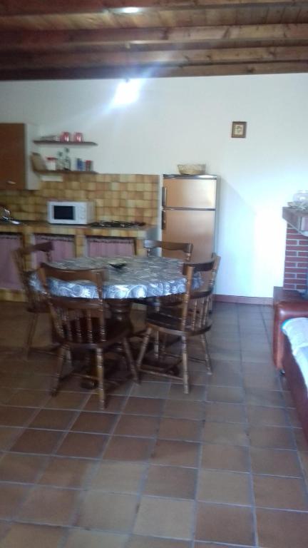 uma cozinha com uma mesa e cadeiras e um frigorífico em Su Nuragi em Santa Maria Navarrese