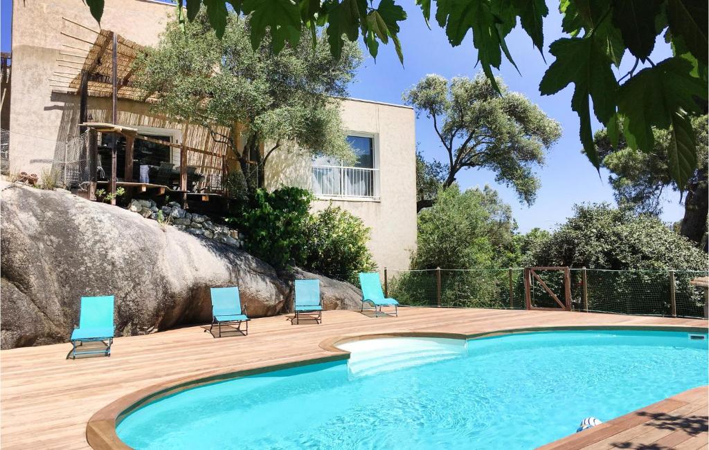 カルヴィにあるAmazing Home In Calvi With 3 Bedrooms, Private Swimming Pool And Outdoor Swimming Poolのスイミングプール(椅子付)と建物
