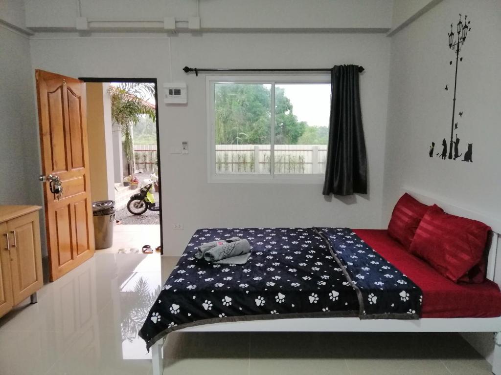 uma cama num quarto com uma janela em เพลินเพลิน​ วิลล่า em Sattahip