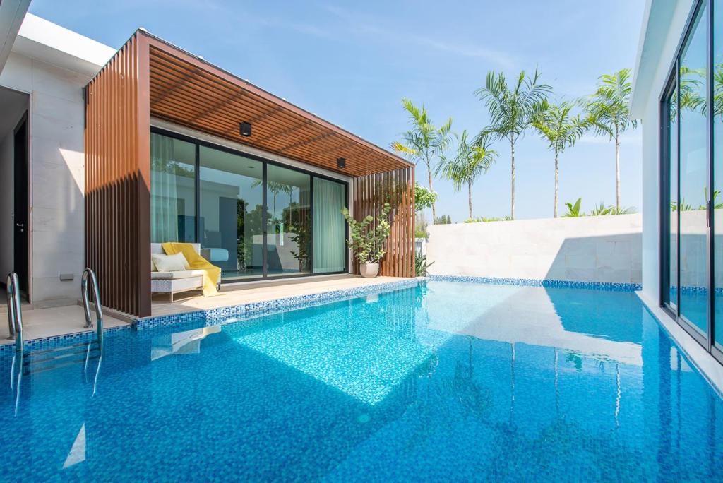 a swimming pool in front of a house at Movenpick Luxury Villa1FL-Private Pool-SHA CERTIFIED in Na Jomtien