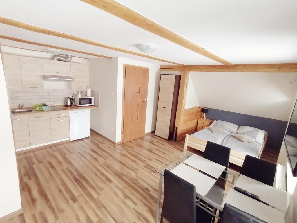 a living room with a table and a kitchen at Apartamenty Wiktora in Polanica-Zdrój