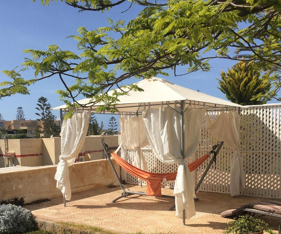 a hammock in a gazebo on a patio at Virginia Beach Standalone Villa in El Alamein