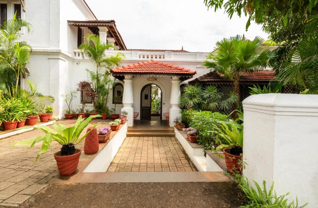an entrance to a white house with plants at amã Stays & Trails Villa No 1, Goa in Old Goa