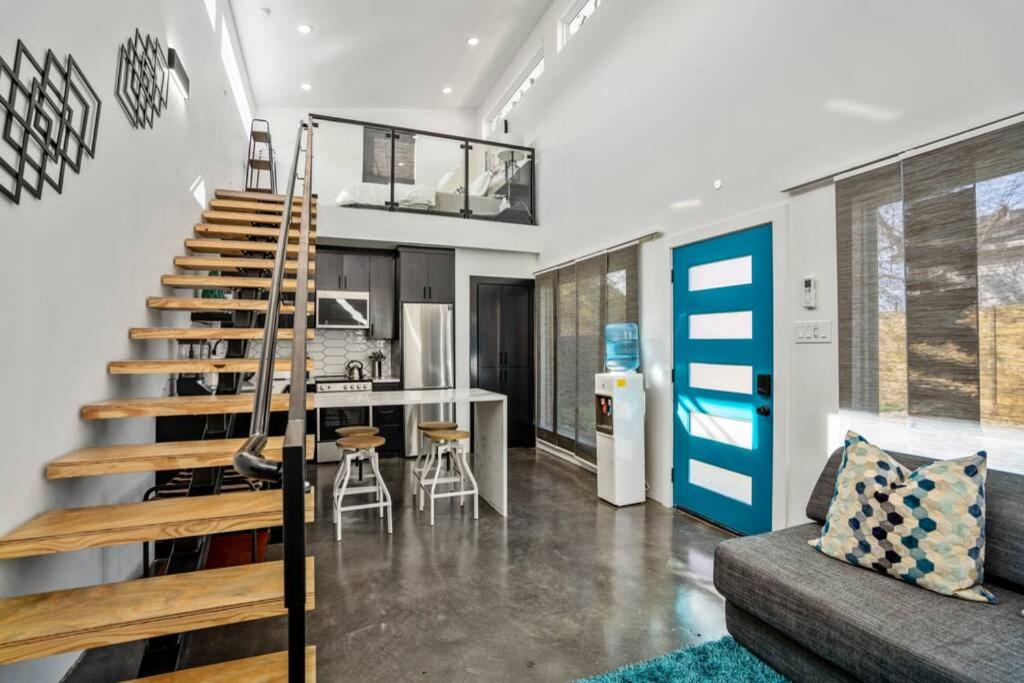 ein Wohnzimmer mit einer Treppe und eine Küche in der Unterkunft Quantum Tiny Loft at East End Revitalized in Houston