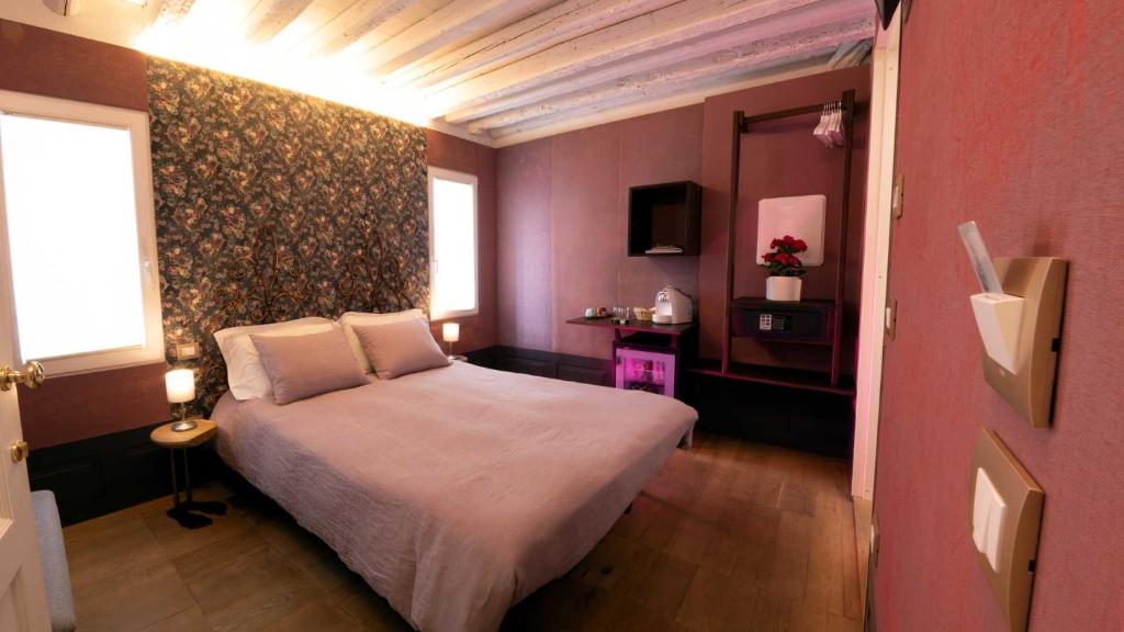 キオッジャにあるCasa Sanseraのピンクルームのベッドルーム1室(大型ベッド1台付)