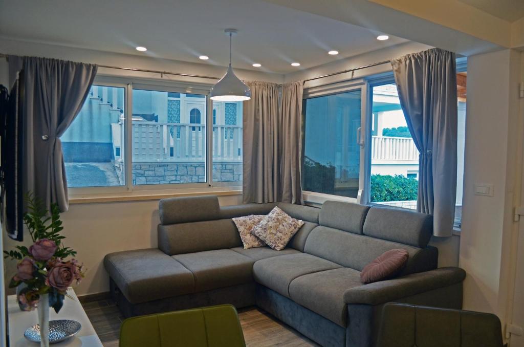 - un salon avec un canapé et de grandes fenêtres dans l'établissement Apartments Rina - Kneže, à Račišće