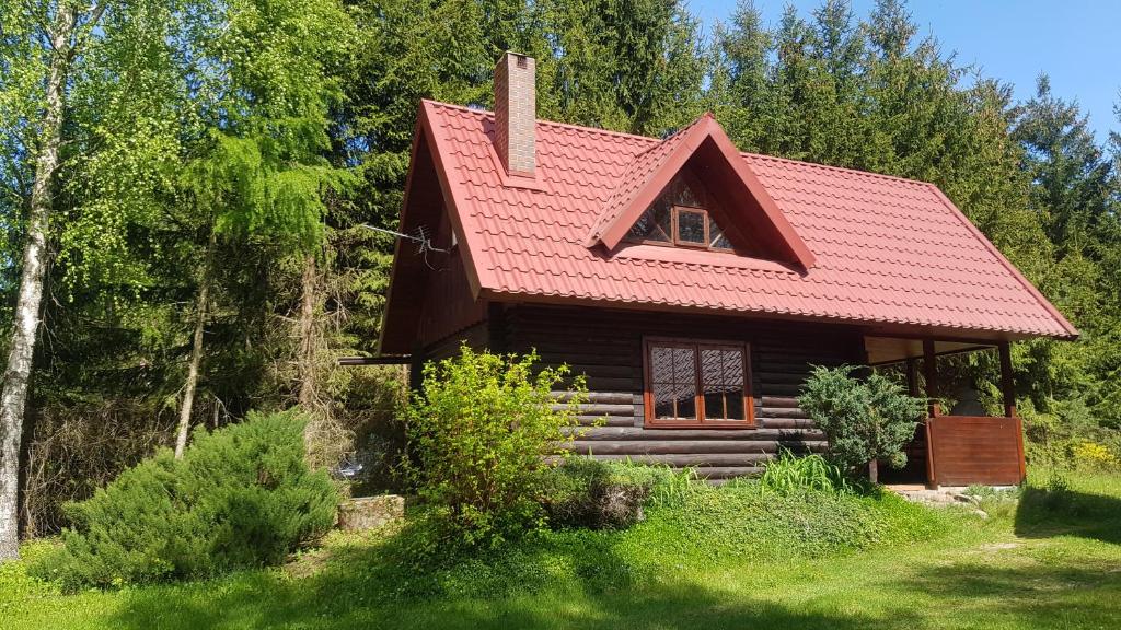 a small log cabin with a red roof at Zacisze in Kukle