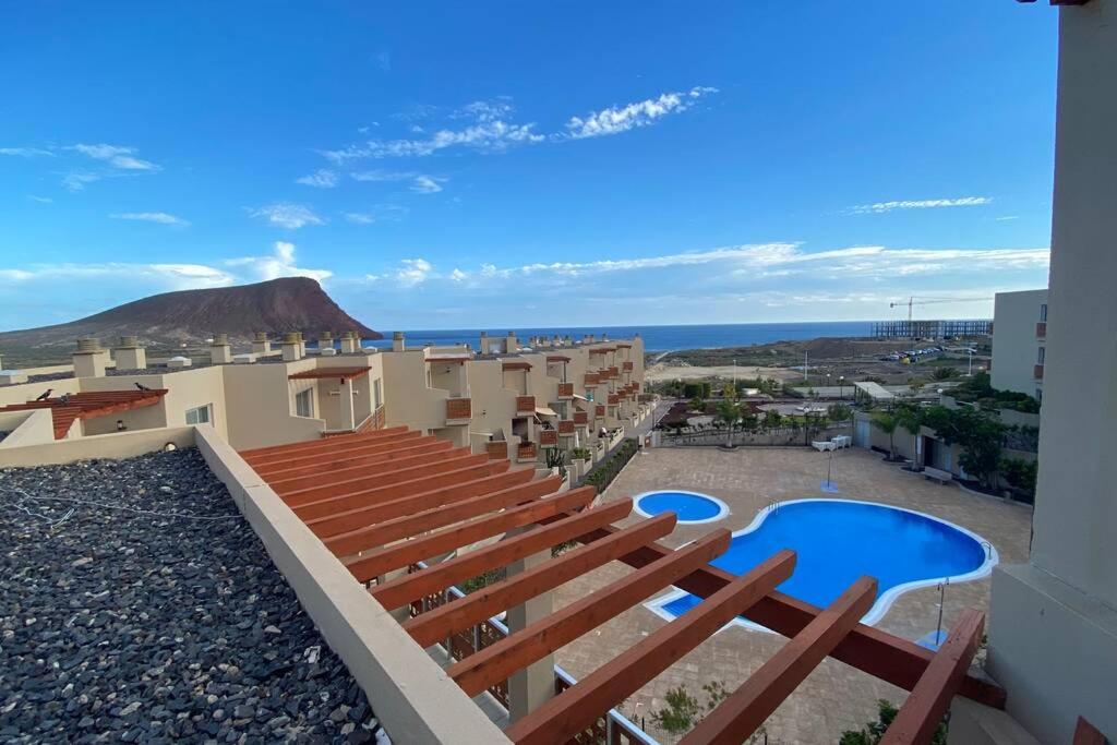 a view from the balcony of a building with a swimming pool at Grande apartamento, Sotavento 3, La Tejita, El Medano in Granadilla de Abona