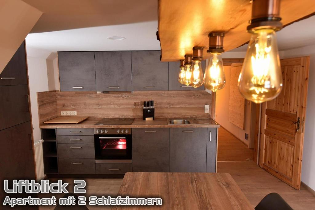 a kitchen with gray cabinets and a wooden table at Ferienwohnungen "Liftblick 2 oder 3" im Kurort Altenberg in Kurort Altenberg