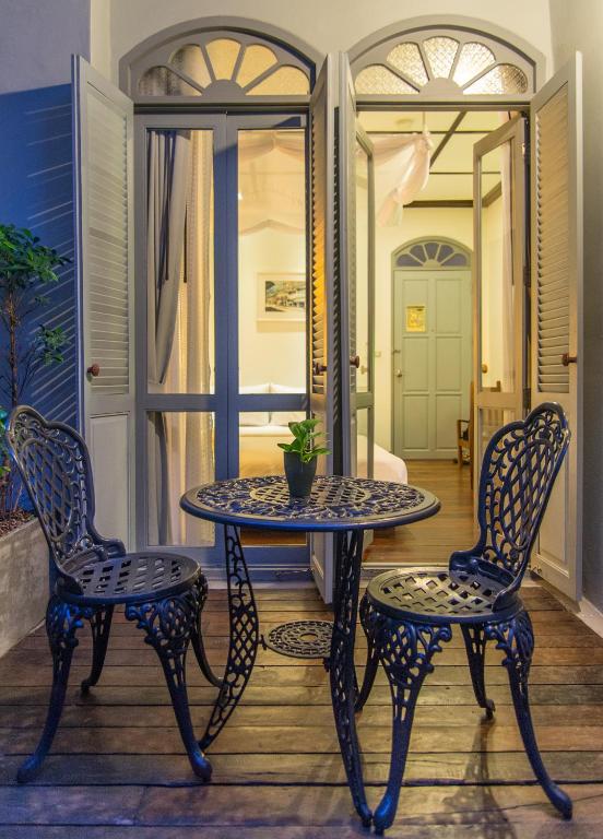 un tavolo e due sedie su un portico di The Memory at On On Hotel a Phuket