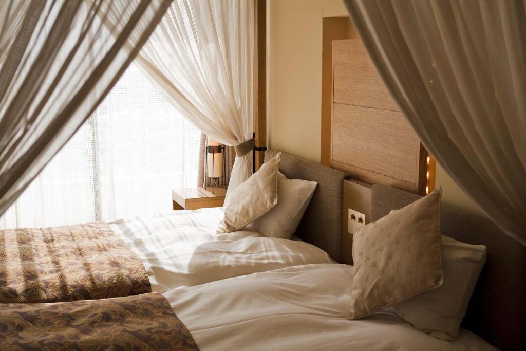 Postel nebo postele na pokoji v ubytování Dogo Prince Hotel