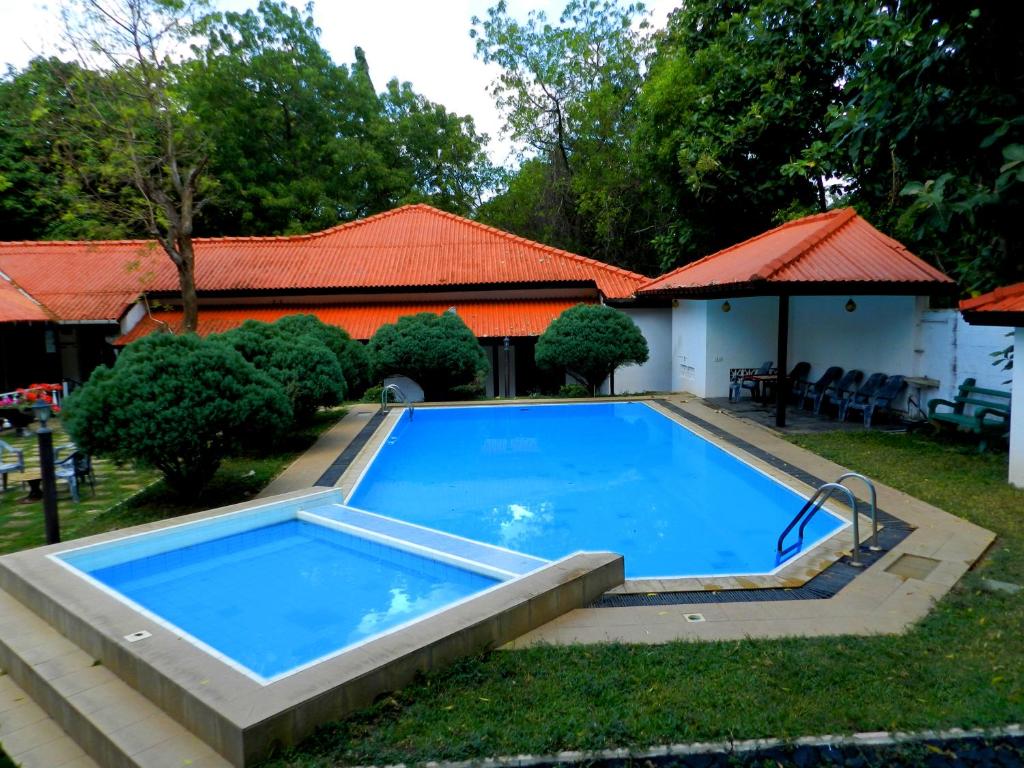 een zwembad in de tuin van een huis bij Jayasinghe Holiday Resort in Kataragama