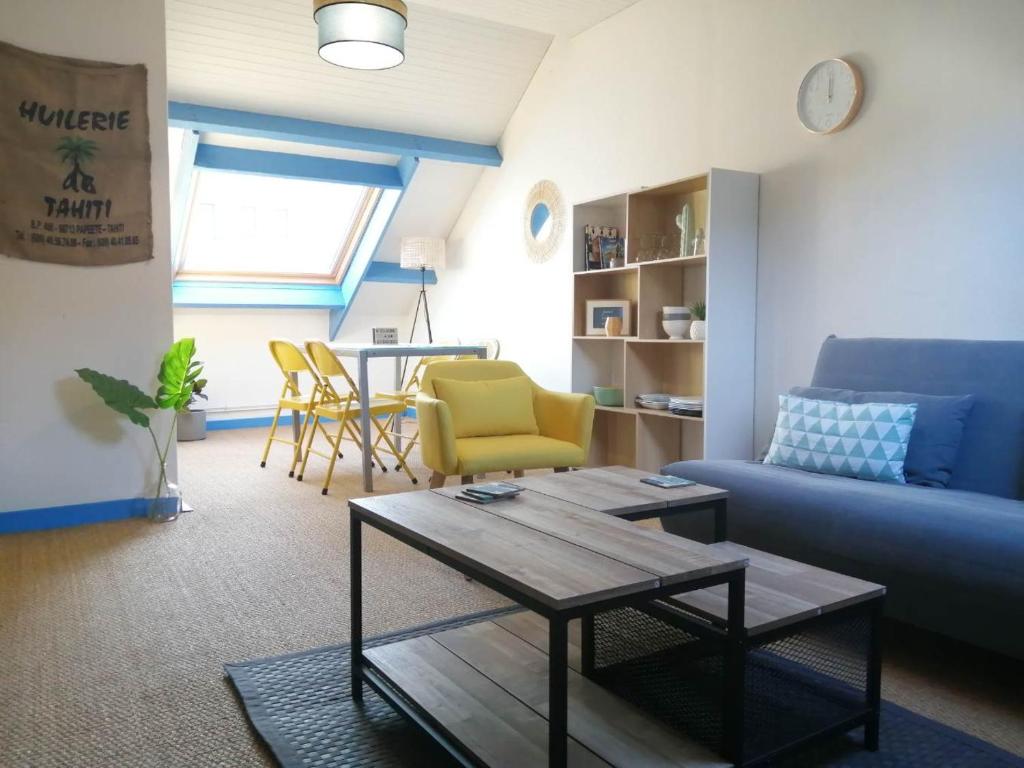 ein Wohnzimmer mit Sofa und Tisch in der Unterkunft Grand et Charmant 3 pièces Breton Saint Brieuc Centre in Saint-Brieuc